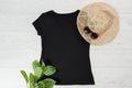 T shirt black. T-shirt Mockup flat lay with summer accessories. Hat and sunglasses on wooden floor background. Copy space. Royalty Free Stock Photo