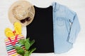 T shirt black and slippers. T-shirt Mockup flat lay with summer accessories. Hat, yellow flip flops and sunglasses on wooden floor Royalty Free Stock Photo