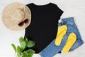 T shirt black and slippers. T-shirt Mockup flat lay with summer accessories. Hat, yellow flip flops and sunglasses on wooden floor Royalty Free Stock Photo