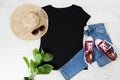 T shirt black and sneakers. T-shirt Mockup flat lay with summer accessories. Hat, jeans and sneakers on wooden floor background. Royalty Free Stock Photo