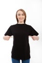 T-shirt design, happy girl concept of smiling woman in blank black shirt pointing her fingers at herself. Place for advertising. Royalty Free Stock Photo