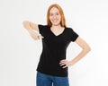 T-shirt design, happy people concept - smiling red hair woman in blank black t-shirt pointing her fingers at herself, red head Royalty Free Stock Photo