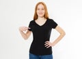 T-shirt design, happy people concept - smiling red hair woman in blank black t-shirt pointing her fingers at herself, red head Royalty Free Stock Photo