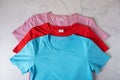 T-shirts in blue, pink and red on a concrete background Royalty Free Stock Photo