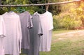 T-shirts hanging on wooden bar for dry after cleaning clothes in the garden outdoor
