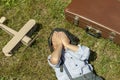 TA boy with an airplane, Happy child dreams of becoming a pilot, lying on the grass, covering his face with his hands