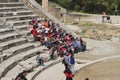 TA group of Asian tourists listens to a guide. On the stairs of the ancient Epidauros theatre, Peloponnese, Greece,