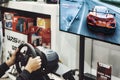 Ta Qali, Malta - 05 November 2022: Unrecognizable person playing a racing simulator video game using a gaming steering wheel