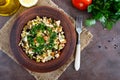 Tabbouleh - hot salad of couscous, meat, fried vegetables and parsley in a clay bowl.