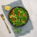 Tabbouleh salad with bulgur, parsley, spring onion and tomato in bowl on grey background. Top view Royalty Free Stock Photo