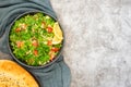 Tabbouleh salad with bulgur, parsley, spring onion and tomato in bowl on grey background. Top view. WIth copy space Royalty Free Stock Photo