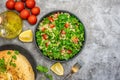 Tabbouleh salad with bulgur, parsley, spring onion and tomato in bowl on grey background. Top view. WIth copy space Royalty Free Stock Photo