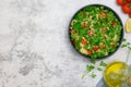 Tabbouleh salad with bulgur, parsley, spring onion and tomato in bowl on grey background. Top view. Copy space Royalty Free Stock Photo