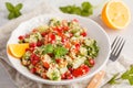 Tabbouleh salad with tomato, cucumber, couscous, mint and pomegranate. Vegan Healthy Food Concept. Traditional middle eastern or