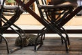 Tabby cat sleeping outside the street garden cafe on a wooden podium among empty tables and chairs. Relax cafe