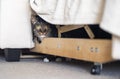 Tabby pet cat peering out from underneath couch Royalty Free Stock Photo