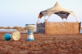 Tabla or darbuka, egyptian music instrument, sandy beach background with summerhouse