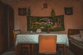 table in abandoned house with hat, glasses, watch and artificial flowers and wall hangings in vintage style