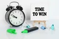 On the table is an alarm clock, a marker and a tripod with a canvas with the inscription - TIME TO WIN Royalty Free Stock Photo