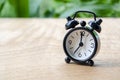 Table alarm clock pointing at 7pm or 7am with customizable space for text. Time management concept and copy space.