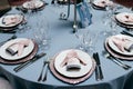 Table appointments. Table setting with empty plates, forks, glasses and knives and light blue tableclothes. Served table in restau Royalty Free Stock Photo