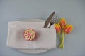 White table place setting with cupcake and springtime tulips