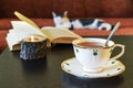 On the table is a beautiful  cup of tea with a spoon, a candle and an open book Royalty Free Stock Photo