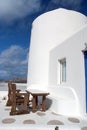 Table and bench in yard of Mykonos, Greece. House on mountain landscape, architecture. Building with whitewashed walls Royalty Free Stock Photo