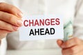 On the table are bills, a bundle of dollars and a sign on which it is written - CHANGES AHEAD. Finance and economics concept Royalty Free Stock Photo