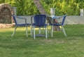 Table and blue four chair in the garden with green lawn grass Royalty Free Stock Photo