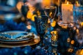 A table with a blue tablecloth and a black wine glass with a gold napkin Royalty Free Stock Photo