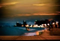 Table on Blur Light Bokeh and Sea Beach Sand Summer Party Night Bar Background,Desk Counter with View Sunset Outdoor Dinner at Royalty Free Stock Photo