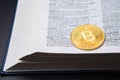 A table with book and bitcoin on a page with Money definition