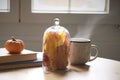 Table with books, cup of coffee or tea with autumn deco arrangement, colourful leaves and mini pumpkin. Reading books at home, Royalty Free Stock Photo