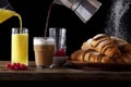 table Breakfast. fresh hot Croissants, Pouring orange Juice, pouring Coffee into milk. ripe Berries