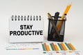 On the table are business charts, office supplies and a notepad with the inscription - stay productive Royalty Free Stock Photo