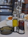 Table in cafe served by small bottles with olive oil and balsam vinegar and a glass ashtray Royalty Free Stock Photo