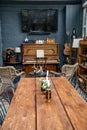 Table with candles and flowers in room with piano. interior in retro style