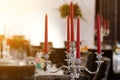 On the table is a candlestick made of metal with red candles. Decoration for holiday or celebration. selective focus. Royalty Free Stock Photo