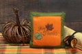 Table centerpiece of a wicker pumpkin, napkin and Give Thanks mini pillow