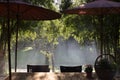 table and chair and red umbrella at patio with light ray through Royalty Free Stock Photo