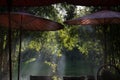 table and chair and red umbrella at patio with light ray through Royalty Free Stock Photo