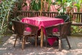 The table and chair set to relax in the garden above and the chair is made of rattan in brown and the table has red tablecloths Royalty Free Stock Photo