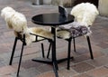 Table and chairs with fur cape outdoors near the restaurant