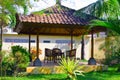 A table with chairs in pavilion among tropical pl