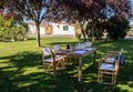 Table and chairs set up under the trees and prepared for the wine tasting. Royalty Free Stock Photo