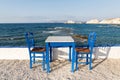 Table and chairs standing on the coast of Aegean sea in Greek island of Milos Royalty Free Stock Photo