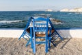 Table and chairs standing on the coast of Aegean sea in Greek island of Milos Royalty Free Stock Photo