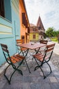 Table with chairs on stone paved old street and colored houses f Royalty Free Stock Photo