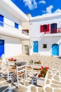 Table with chairs in tavern on Parikia town square with typical Greek houses, Paros island, Greece Royalty Free Stock Photo